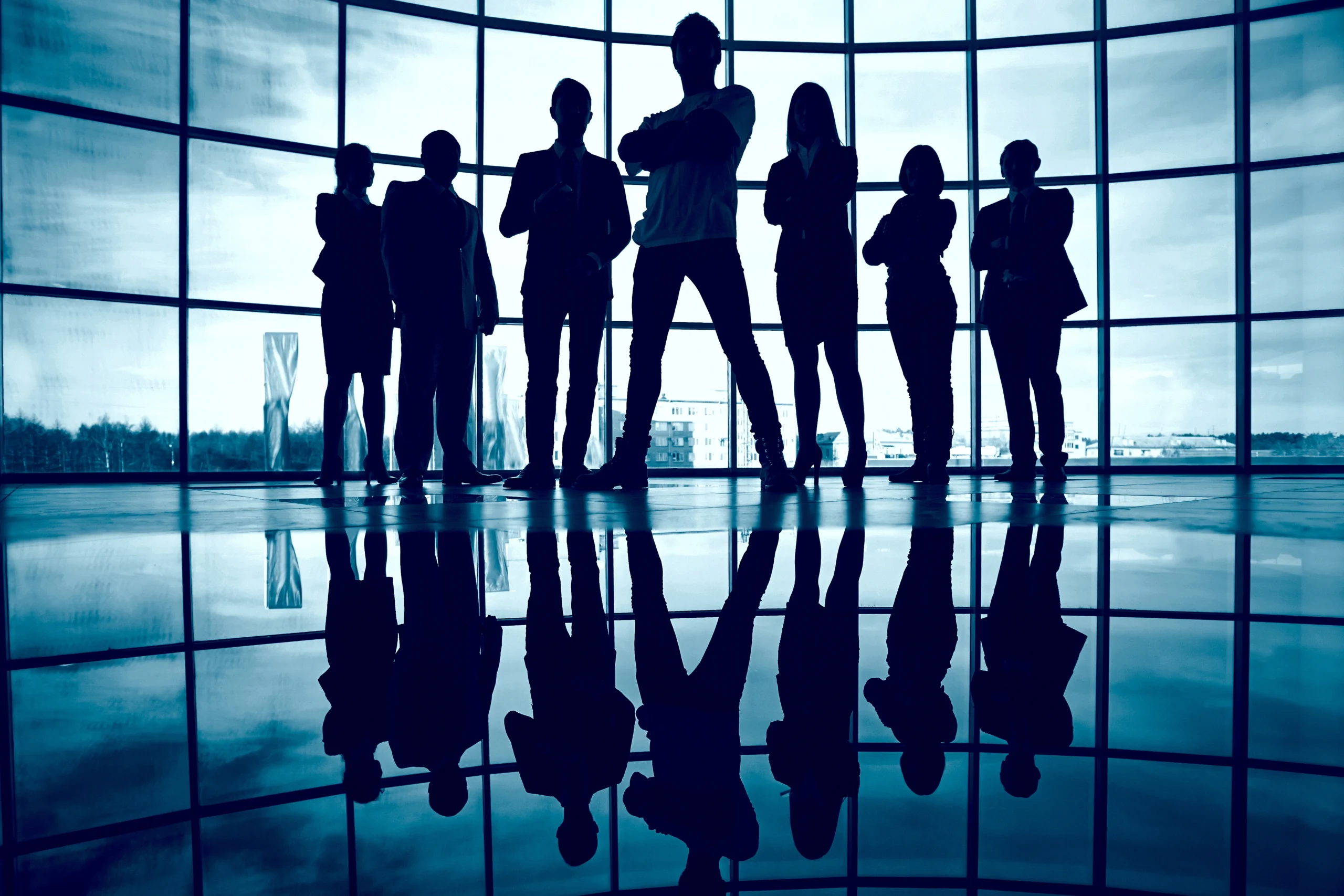 a group of people standing in front of a large window